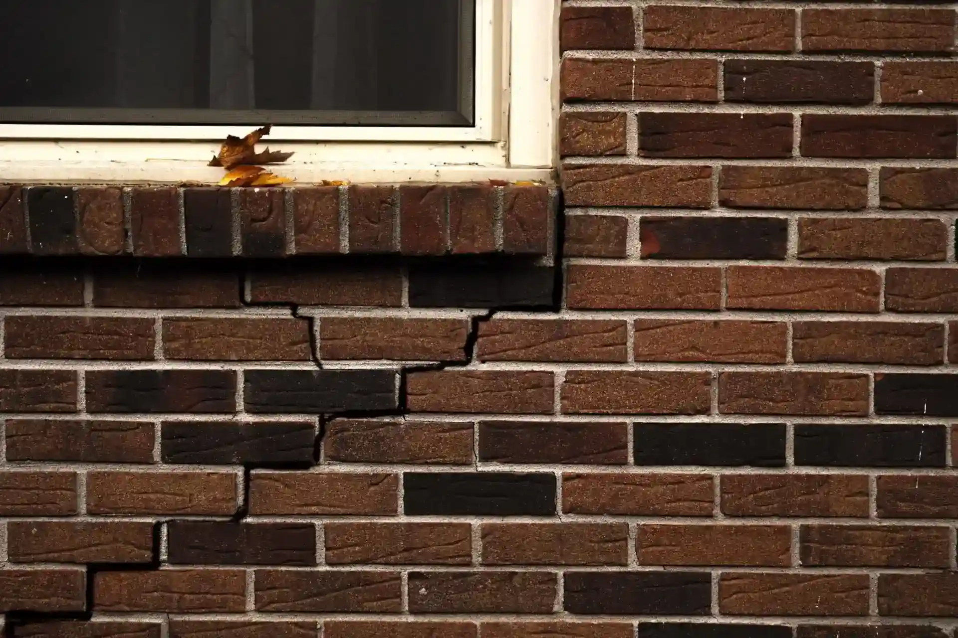 cracked-red-brick-exterior-under-window-scaled